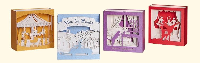 Quatre cartes pop-up en 3D : manège de naissance, danseuse, et carte d’anniversaire avec un chat curieux explorant des cupcakes.